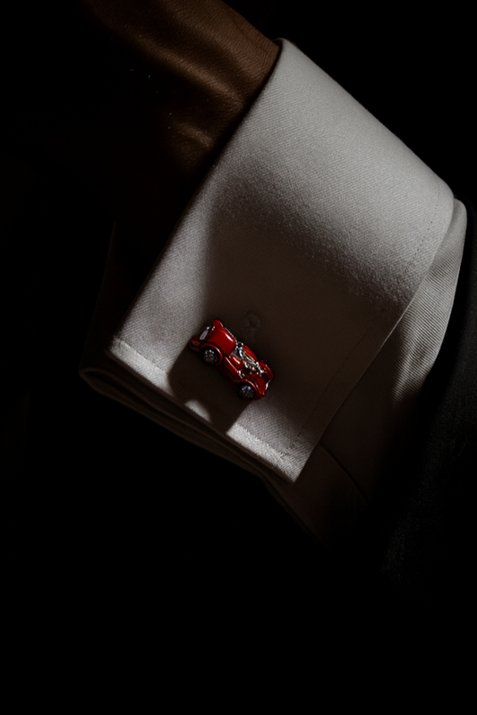 Close-up of a cufflink on a white shirt against a dark background